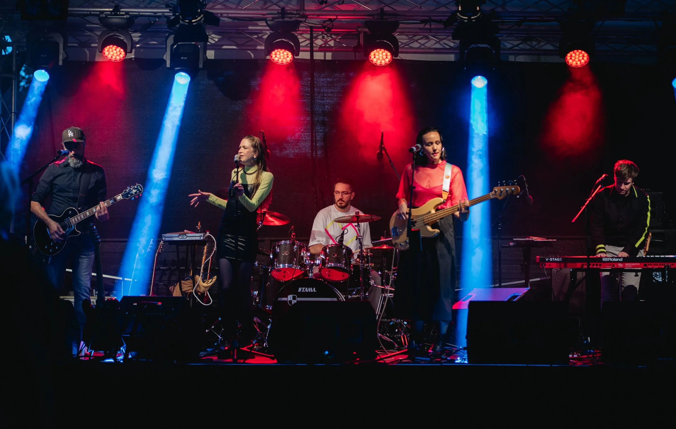 Die fünf Bandmitglieder live auf der Bühne mit blauem und rotem Licht