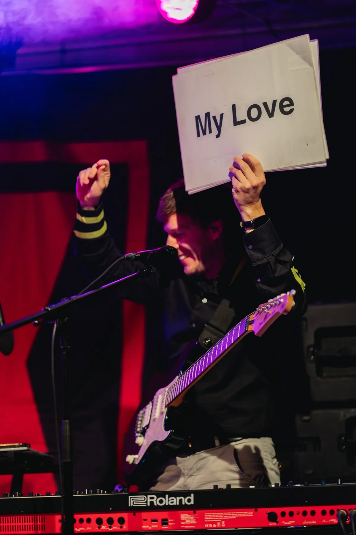 Tobias hält ein Schild mit „My Love“ hoch